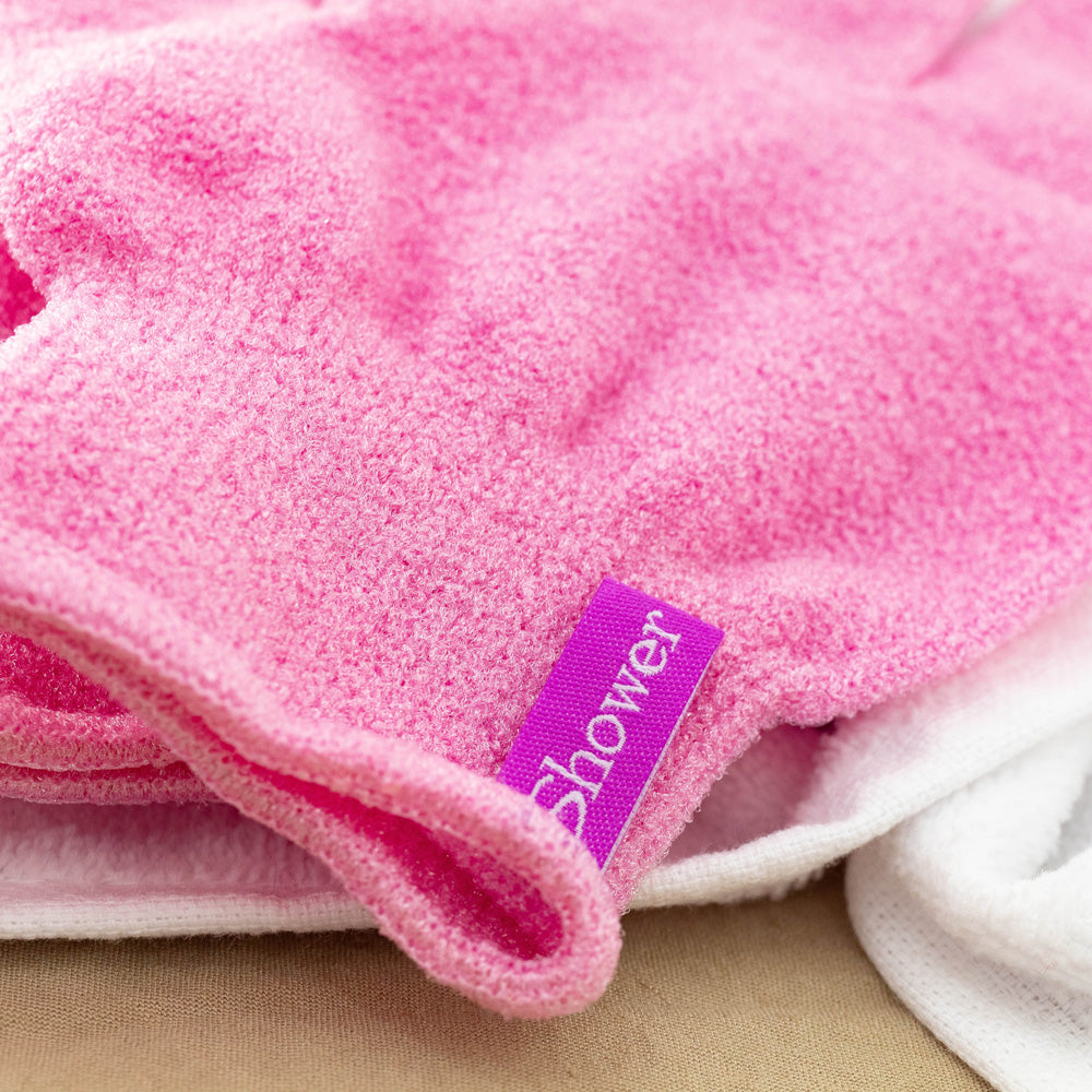 Close-up of pink Korean exfoliating shower glove